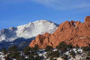 The red rocks of Garden of the Gods with Pikes Peak behind them.